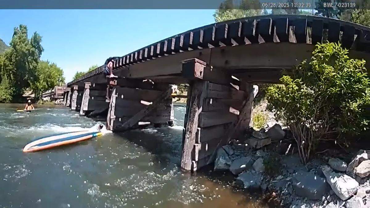 Bystanders helped hold a trapped paddleboarder’s head above water on a Utah river, video shows.