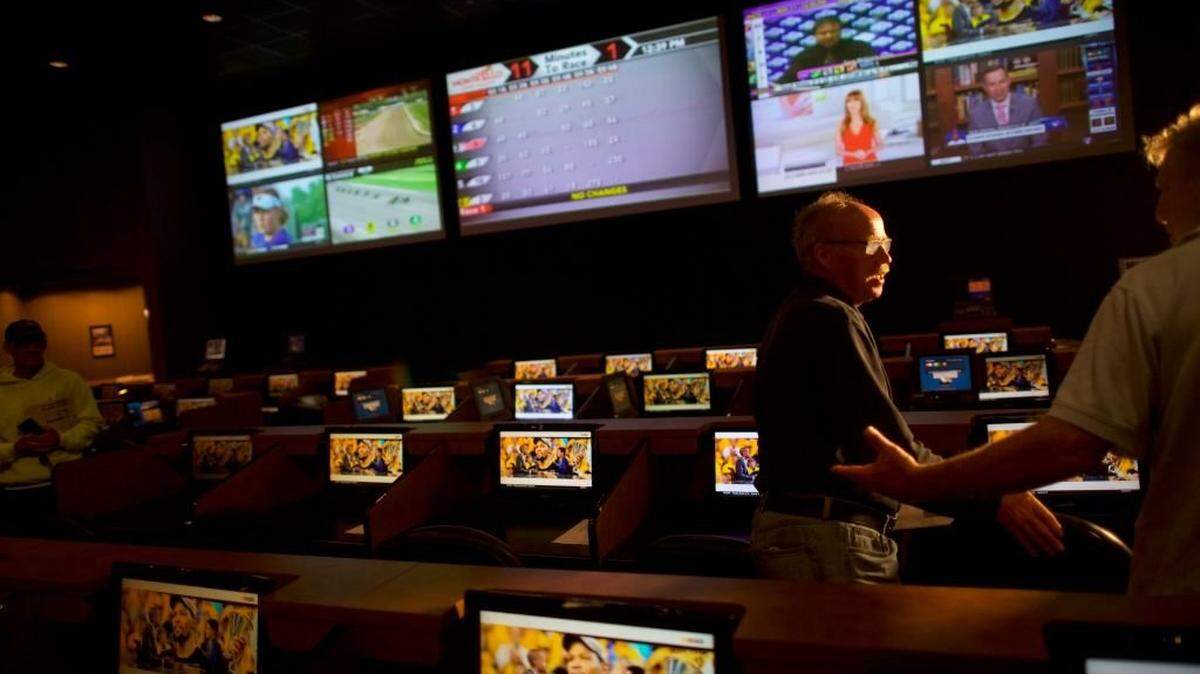 DOVER, DE - JUNE 5:   (2nd R) Gerry Dennison, 63, speaks with a friend placing his bet at Dover Downs Casino on June 5, 2018 in Dover, Delaware.  Delaware is the first state to launch legal sports betting since the Supreme Court decision to lift a 25-year old federal ban.  (Photo by Mark Makela/Getty Images)