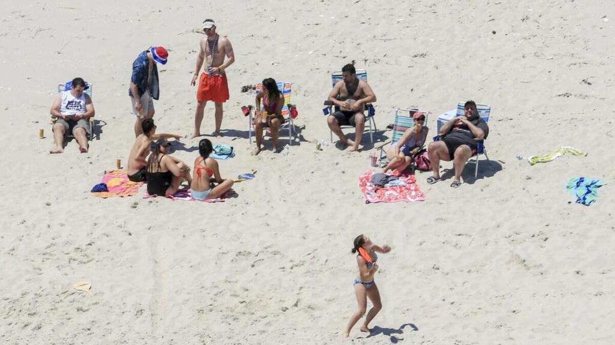 New Jersey Gov. Chris Christie, right, uses the beach with his family and friends at the governor's summer house at Island Beach State Park in New Jersey. Christie is defending his use of the beach, closed to the public during New Jersey’s government shutdown, saying he had previously announced his vacation plans and the media had simply “caught a politician keeping his word.”
