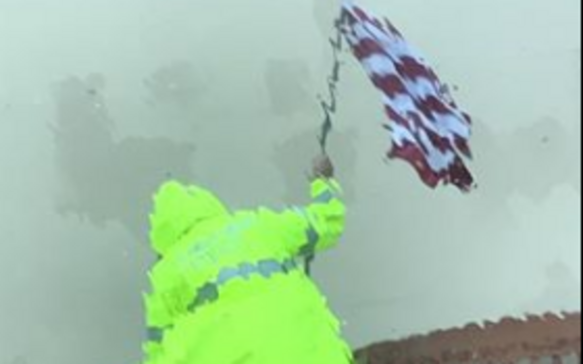 Officer Jack McCarty of the Aransas Pass Police Department battles Hurricane Harvey to rescue an American flag.