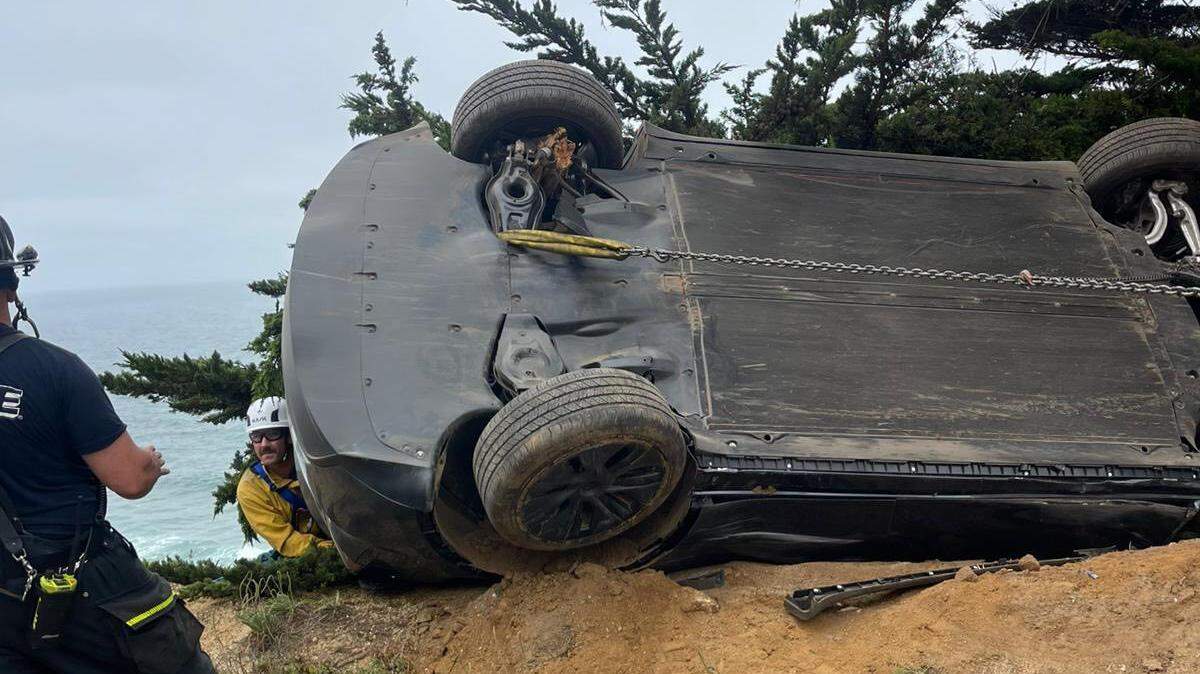 Rescuers used ropes to stabilize the vehicle as it hung over the 200-foot cliff on a tree, then rescued the trapped driver through the back window, firefighters said.