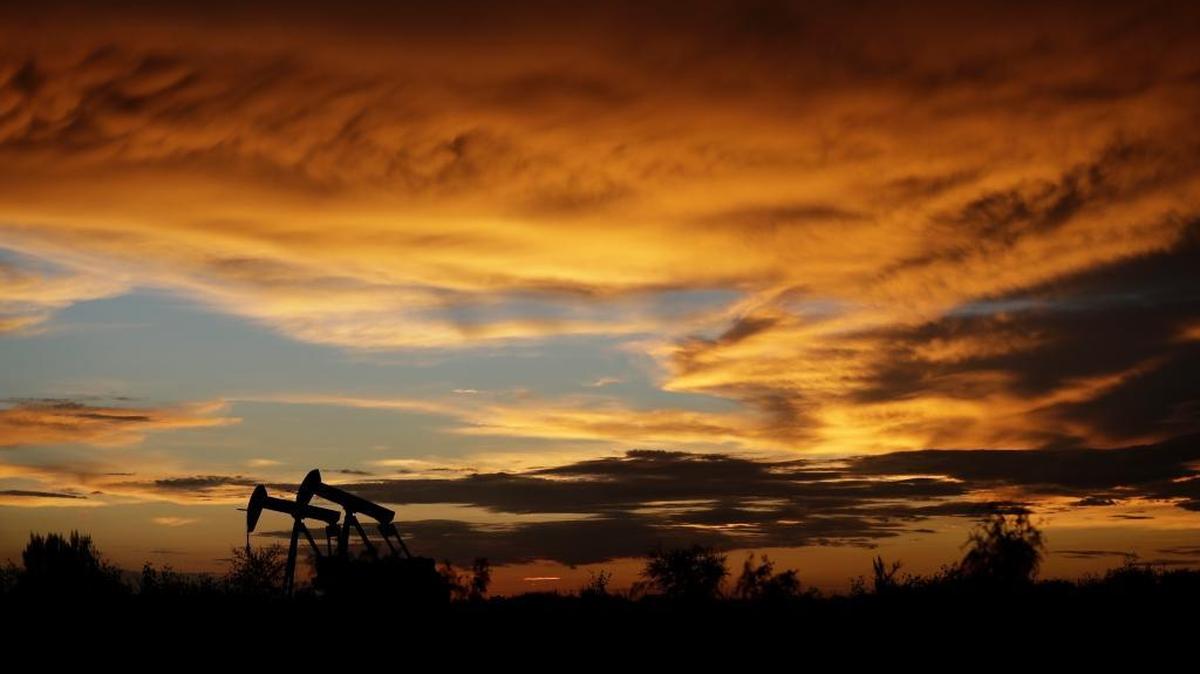 Pumpjacks work in an oil field at sunset after a thunderstorm passed through the area Monday in Karnes City, Texas. A new company, Conservative Move, wants to get conservatives from other states to move to Texas.