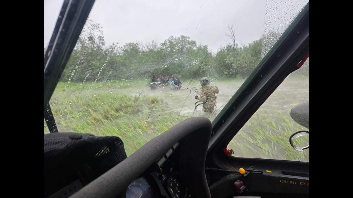 Alaska Army National Guard Chief Warrant Officer 3 Nick Lime helps people trapped June 30 on a river in Alaska during a storm, officials said.