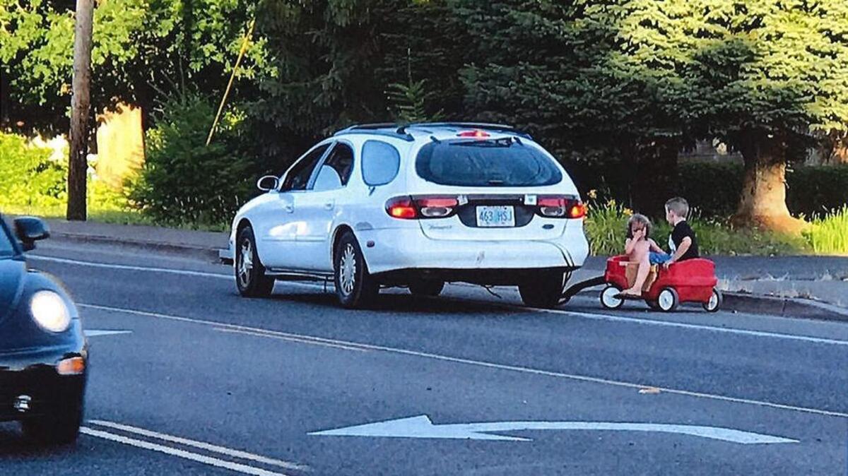 A witness photo shows children in a red wagon being towed by a car in Springfield, Ore., on Wednesday, July 12, 2017.
