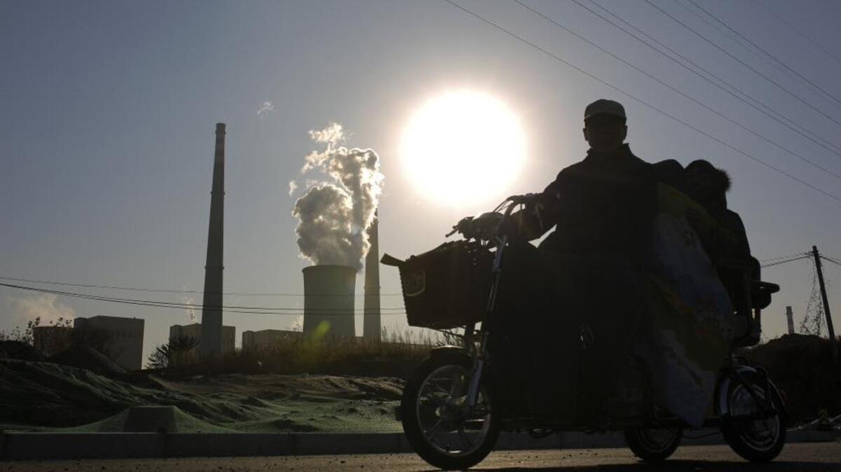 Scientists cite greenhouse gas emissions, such as these emanating from a coal-fired power plant in Beijing, as a factor in the steady climb of the Earth’s temperature, an increase that set a new record in 2015.