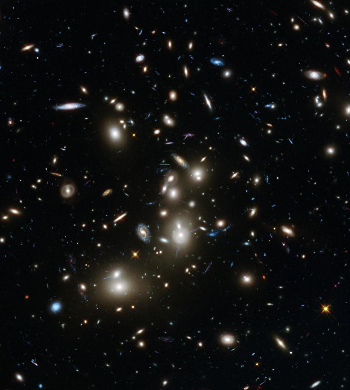 This undated image made available by the European Space Agency shows galaxies in the Abell 2744 cluster, and blue galaxies behind it, distorted and amplified by gravitational lensing. The long-exposure image taken by the Hubble Space Telescope shows some of the intrinsically faintest and youngest galaxies ever detected in visible light.