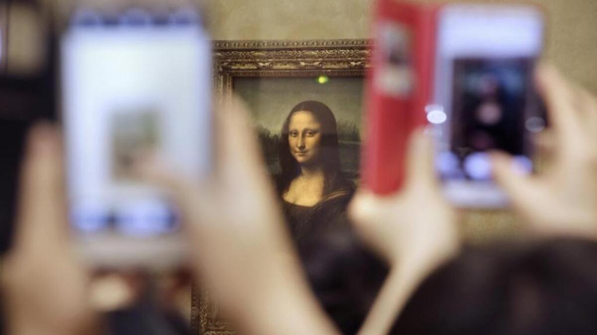 Tourist take pictures for Leonard de Vinci's La Joconde painting, Mona Lisa, at the Louvre museum in Paris, France, Thursday, Nov.19, 2015.
