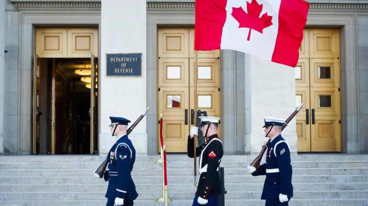 A military honor guard carries the Canadian flag past the Pentagon on Feb. 6. A Canadian sniper has broken the distance record for a gunshot kill.
