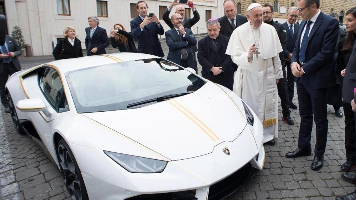 Pope Francis speaks with Lamborghini CEO Stefano Domenicali next to a white Huracán donated to the pontiff by the luxury sports automaker Wednesday in Vatican City. It will be auctioned, with proceeds going to charity.
