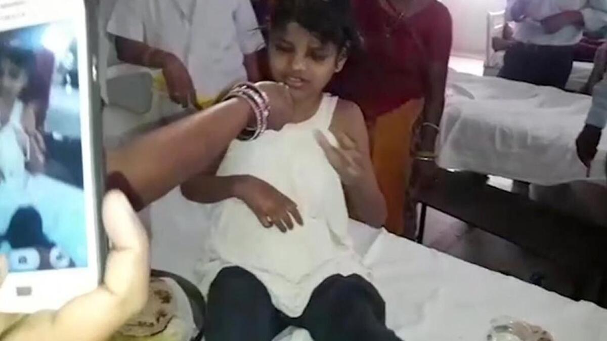 A young Indian girl sits on a bed at a hospital in this image taken from video in Bahraich northern India Thursday. Indian police are reviewing reports of missing children from recent years to try to identify the girl who was found in a forest with a group of monkeys, but officials say reports that she was raised by the monkeys seem improbable.