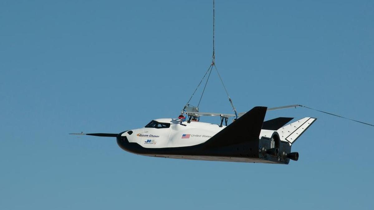 FILE - In this Aug. 22, 2013 photo made available by NASA, the Sierra Nevada Corporation's Dream Chaser spacecraft is carried by a helicopter during a test in Sparks, Nev. On Saturday, Oct. 26, 2013, the Nevada-based company tested a full-scale model at Edwards Air Force Base in California in its first free flight, but after being dropped by a helicopter, the left landing gear deployed too late and the test vehicle skidded off the runway.