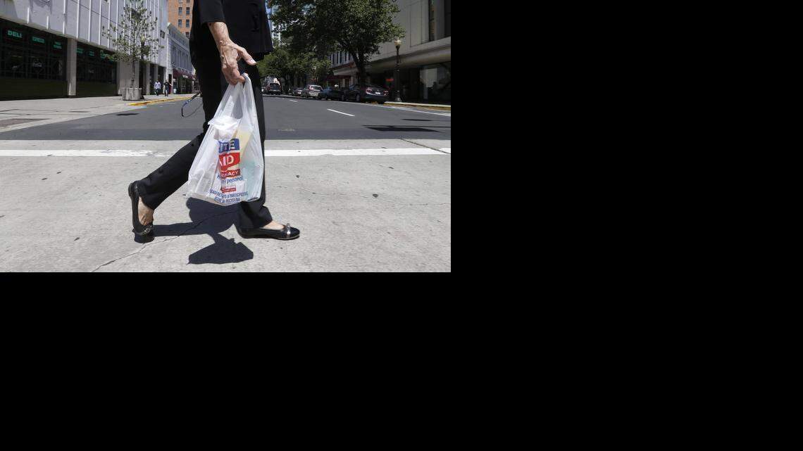 
 A woman walks with a plastic bag in Sacramento, Calif., on Wednesday, May 14, 2014. 
