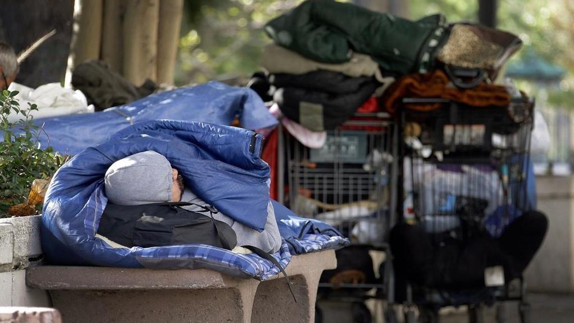 A homeless man rests inside a sleeping bag downtown Los Angeles, on Friday, Nov. 27, 2015.