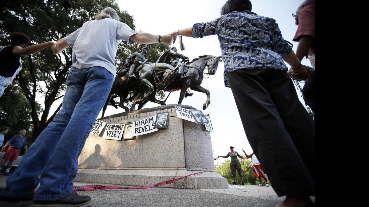 
Activists gather around the Robert E. Lee statute at Lee Park chanting the names of Civil War era activists Tuesday, June 30, 2015, in Dallas.
