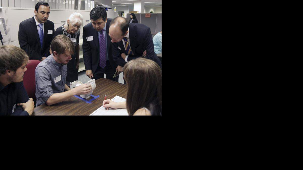 
Observers watch Kern County elections worker Micah Kagler, seated, second from left, read a ballot during the recount in the California controller’s race last summer. The recount ended after about a week. (AP Photo/The Bakersfield Californian, Felix Adamo)
