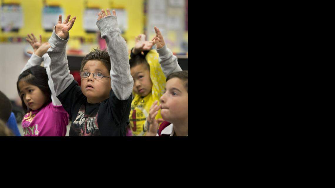 
First-grader Robert Olvera raises his hands during a math lesson in his classroom at Raymond Case Elementary School in Elk Grove in April 2013. The California Building Industry Association and Coalition for Adequate School Housing are part of a group trying to qualify a $9 billion bond for the November 2016 ballot.

