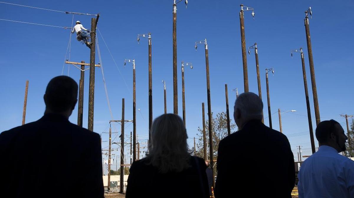Spectators watch as apprentice lineman Darin Floyd demonstrates ‘sagging’ an electrical power line at the Sacramento Municipal Utility District training academy on Nov. 6, 2015. Transportation and utility employers pay the state’s highest workers’ compensation insurance premiums because of the dangers of their work.