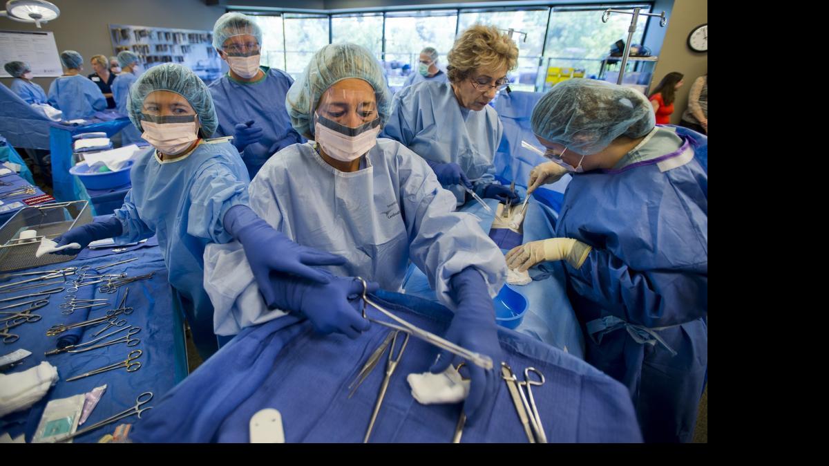 
Registered nurses work in a simulated surgical procedure with abdominal bleeding with instructor and RN Susan Flynn, second from right, at the Sutter Health University operating room RN training program in Sacramento on June 26, 2014.. An Assembly committee has rejected legislation that would allow nurse practitioners to treat patients without direct physician supervision.
