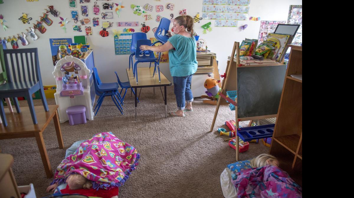 
Tisa Kelley, a Sacramento child care provider, puts away some of the chairs after lunch on May 28, 2015.
