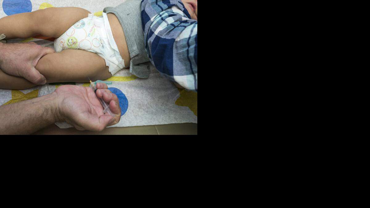 
A pediatrician vaccinates a 1-year-old with the measles-mumps-rubella (MMR) shot in Northridge in January.
