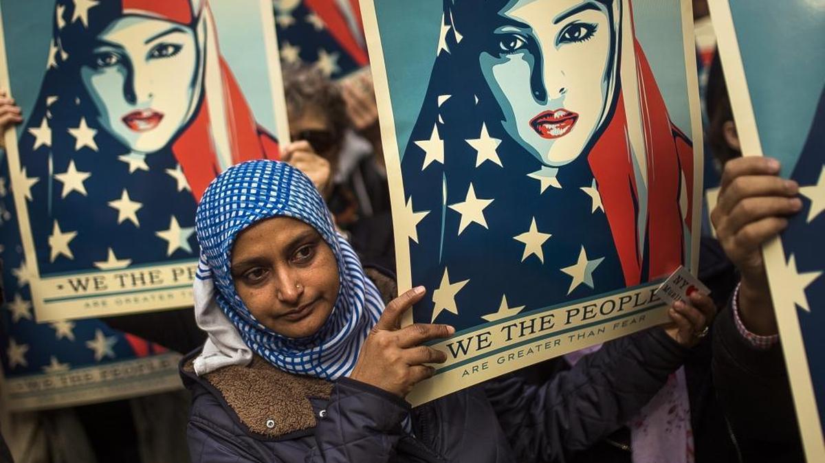 People carry posters during a rally against President Donald Trump's executive order banning travel from seven Muslim-majority nations, in New York's Times Square, Sunday, Feb. 19, 2017.