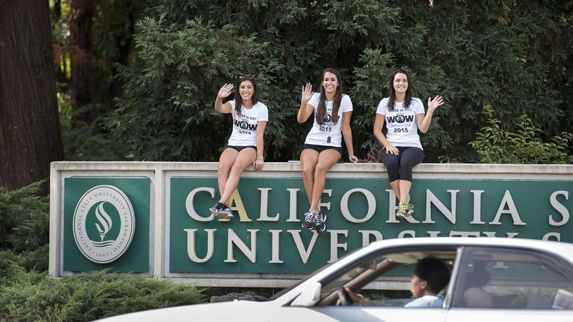 Sacramento State students wave at the J Street campus entrance during move-in day in 2015.