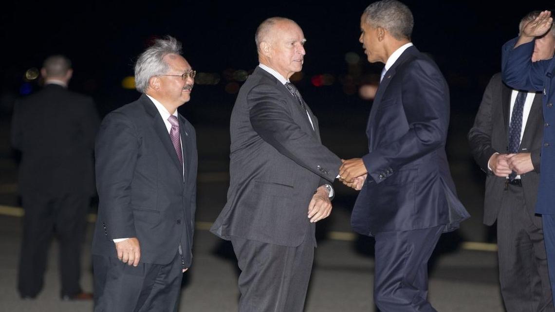 
President Barack Obama, right, is greeted on the tarmac by California Gov. Jerry Brown, center, and San Francisco Mayor Ed Lee, left, at San Francisco International Airport, Friday, Oct. 9, 2015 ,in San Francisco.
