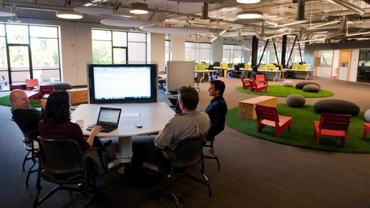 
Workers cluster around the giant computer screen in a "collaboration pod, " at the second floor of Skype's Palo Alto office on Feb. 9, 2011. In the background is the "chill out lounge" with benches, lounge chairs and soft pillow rocks. The SIlicon Valley’s technology-centered economy is leading the state in output gains.
