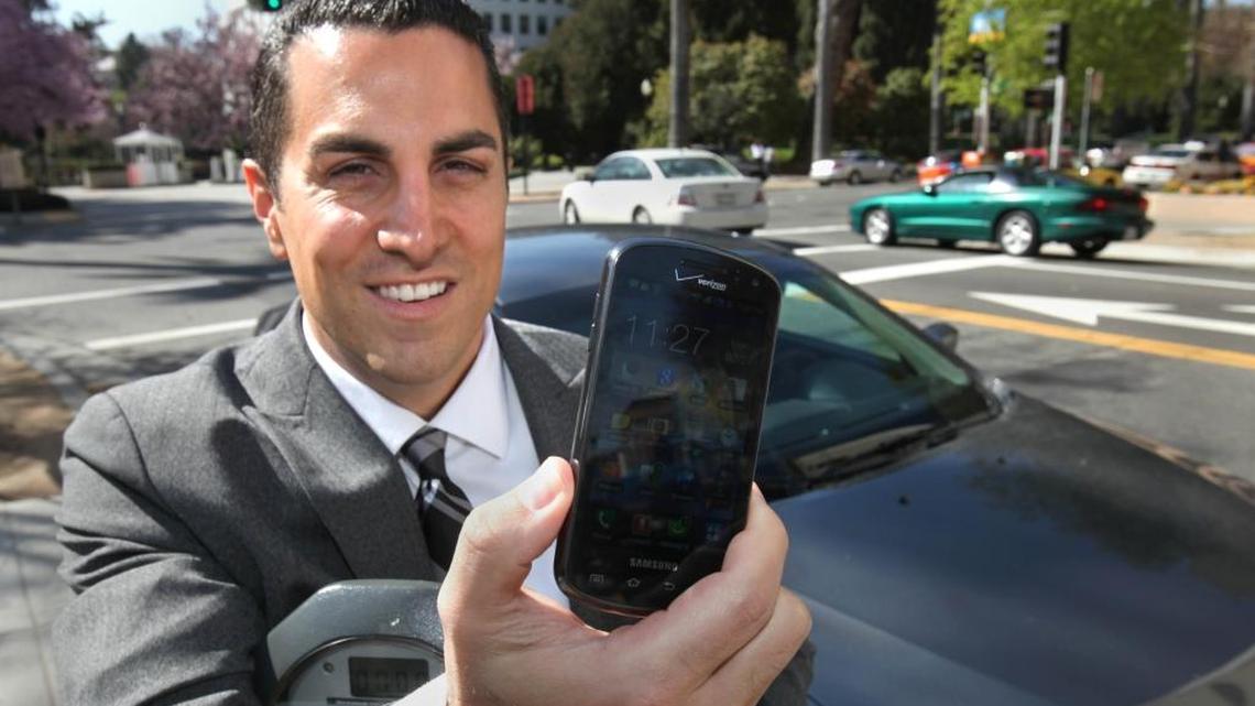 Assemblyman Mike Gatto, D-Los Angeles, displays his cell phone, in Sacramento, Calif., the type of device his proposed legislation would allow California drivers to use to show proof on insurance.