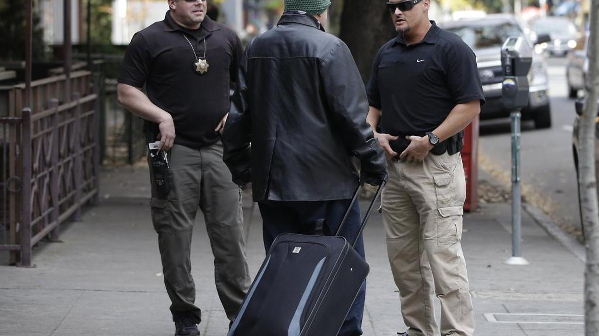 Parole agents Andrew Correa, left, and Clint Cooley, right, talk with a sex-offender parolee they located by tracking the global positioning device he wears, on Dec. 1, 2015, in Sacramento.