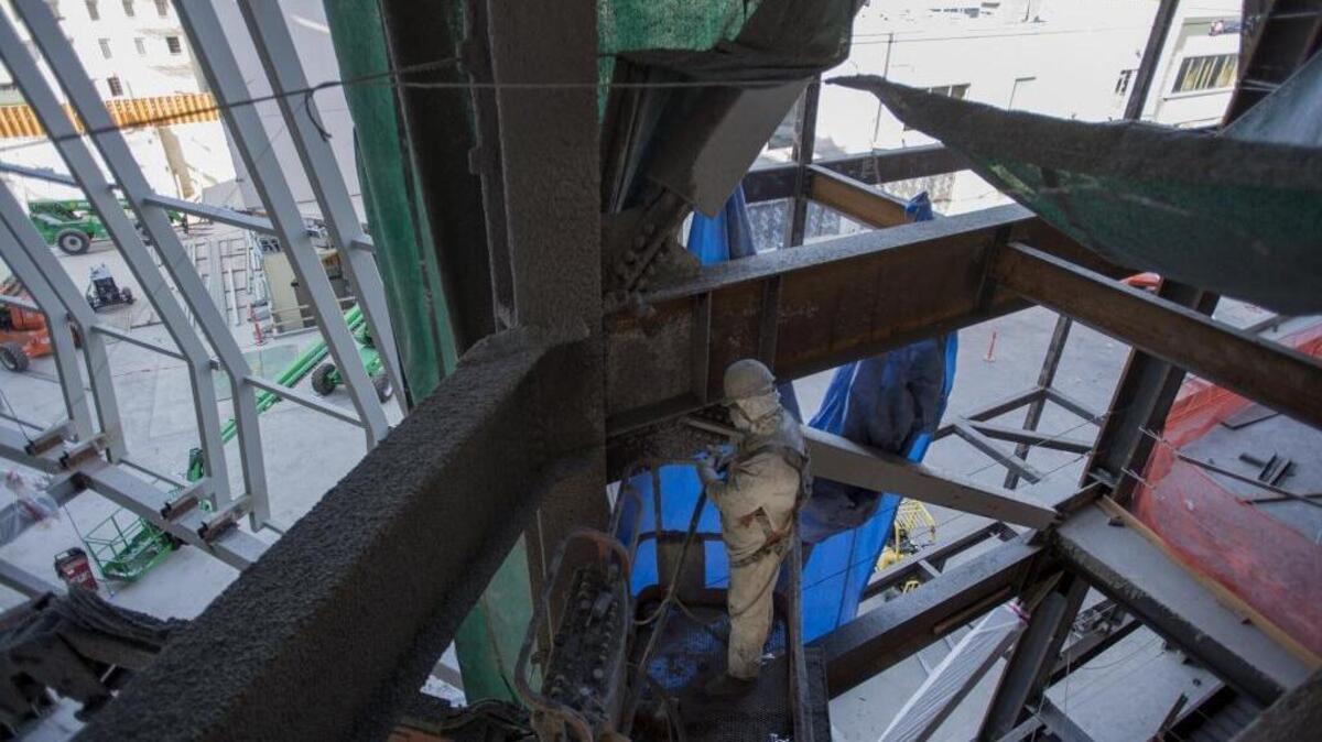 A construction worker coats steel beams at the Golden 1 Arena construction site on August 18. Construction is one of the state’s most dangerous occupations and carries high workers’ compensation insurance premiums.