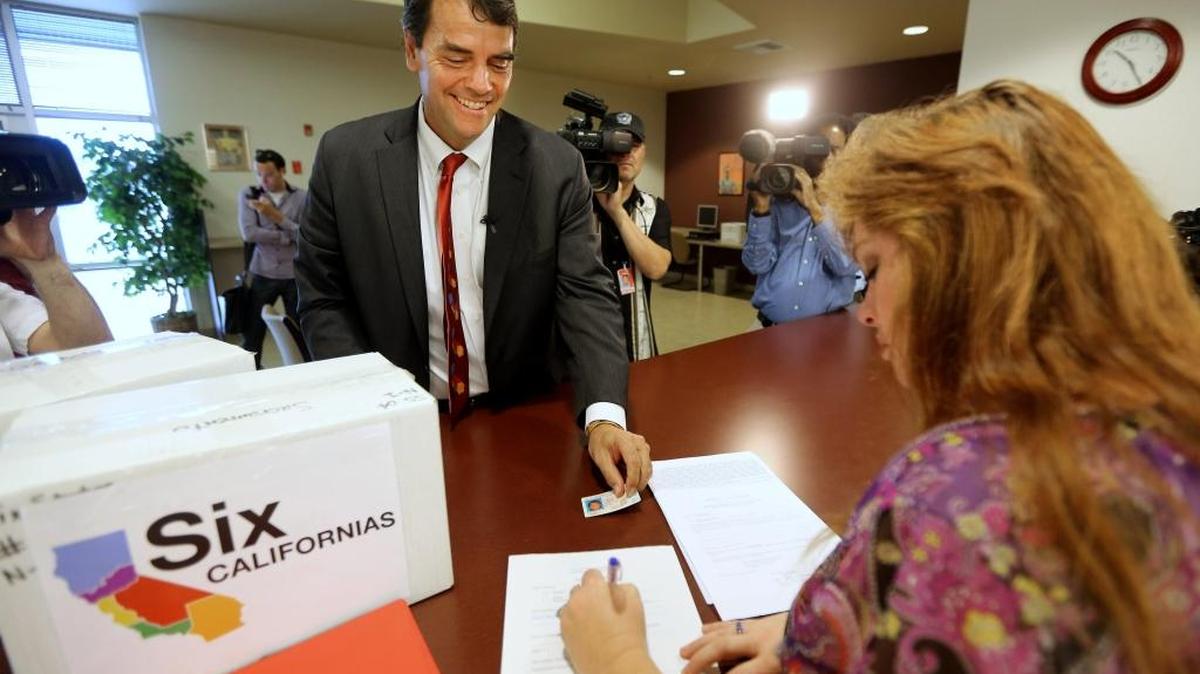 In 2014, Silicon Valley venture capitalist Tim Draper presents his driver's license for identification purposes to Heather Ditty, elections manager for the Sacramento County Registrar of Voters, as he turns in boxes of petitions for a ballot initiative that would ask voters to split California into six separate states in Sacramento. The effort failed to qualify for the ballot then. On Tuesday, Draper's proposal to split California into three states qualified for the November ballot, the Secretary of State's Office announced.