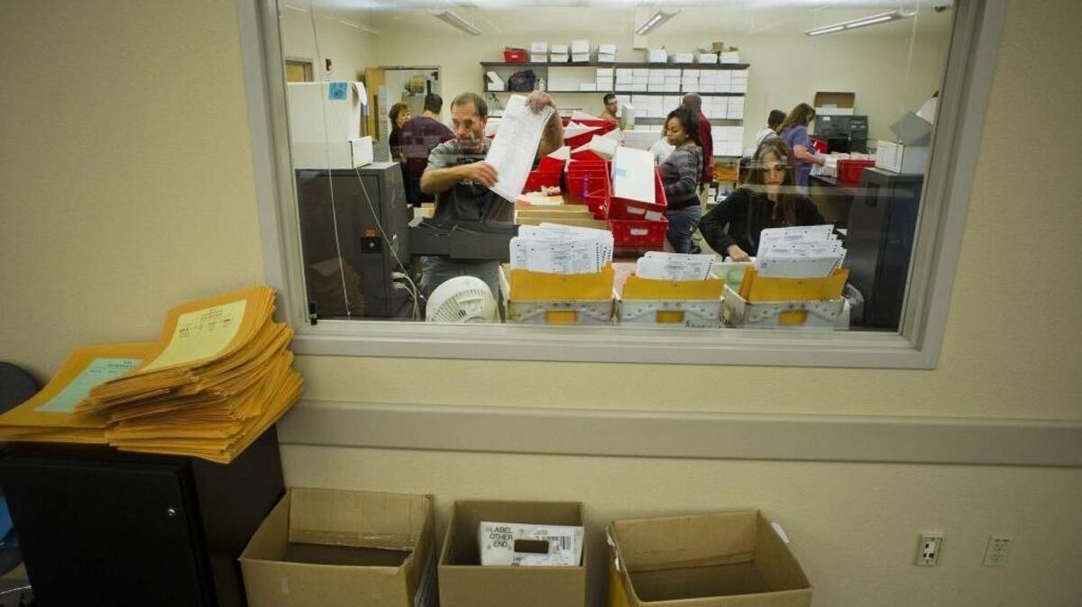 Election officials process the ballots by machine at the Sacramento County Elections office on November 13, 2012.