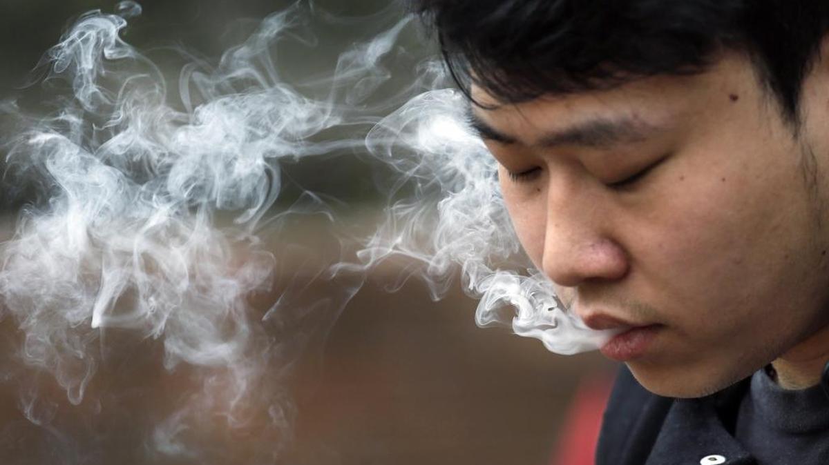 In this photo taken Thursday, Jan. 7, 2016, David Wang, 19, smokes outside during a break from classes at Seattle Central College in Seattle.