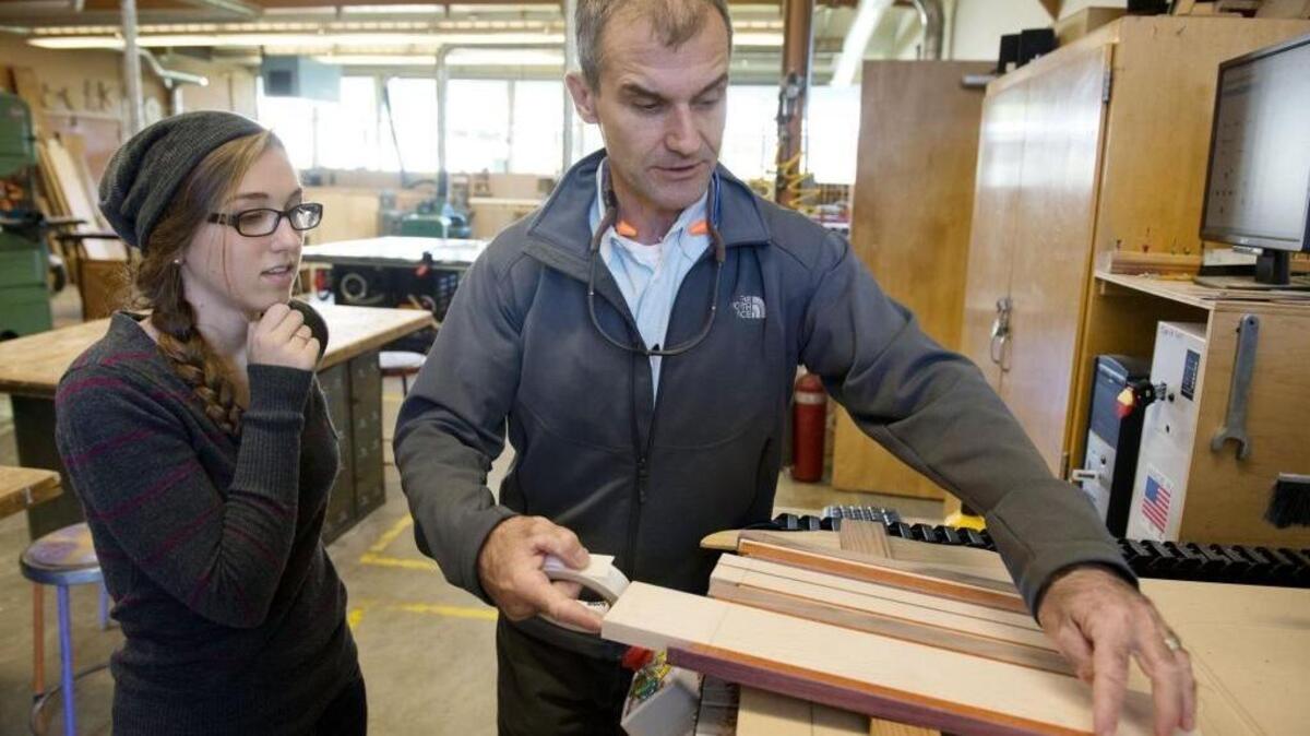 Teacher and inventor Jonathan Schwartz helps Renae D'Amour with her cutting board project in her computer integrated manufacturing class at Colfax High School on Sept. 29, 2014. The classroom boasts 18 computers with software to do computer-aided design and manufacturing, plus a 3-D printer.