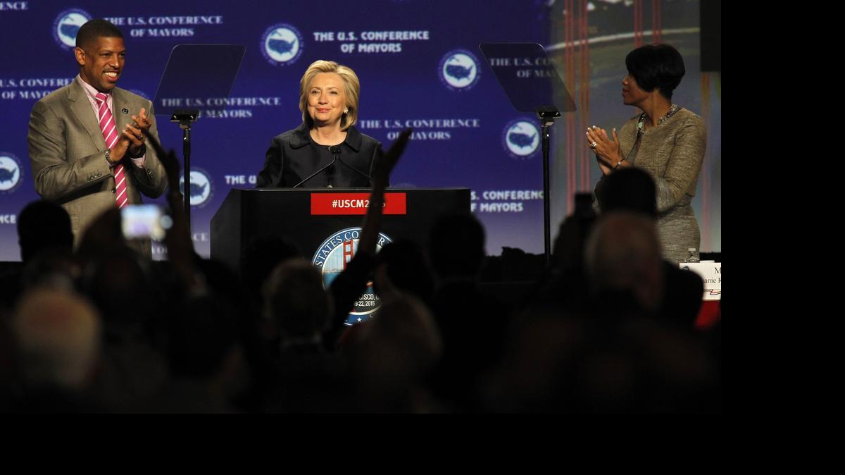 
Democratic presidential candidate Hillary Rodham Clinton is applauded by US Conference of Mayors President, Sacramento Mayor Kevin Johnson, left, and Conference Vice President, Baltimore Mayor Stephanie Rawlings-Blake, Saturday June 20, 2015, at the U.S. Conference of Mayors 83rd Annual Meeting in San Francisco. 
