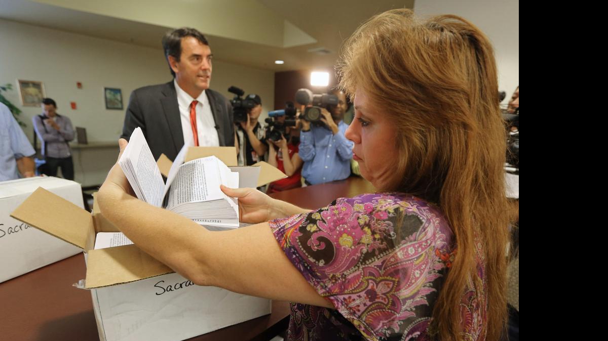 
Heather Ditty, elections manager for the Sacramento County Registrar of Voters, inspects signatures last July for a ballot initiative to split California into six separate states.
