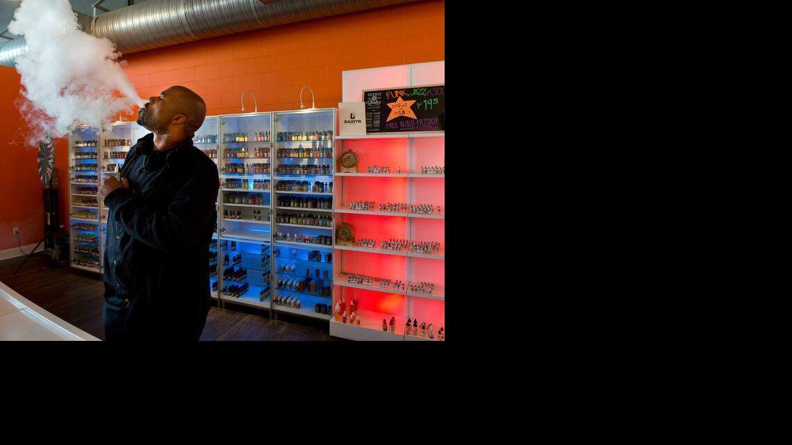 
Mario Weaks, a sales associate at The Vapor Spot on J Street in midtown Sacramento, exhales smoke from his e-cigarette on Wednesday. 
