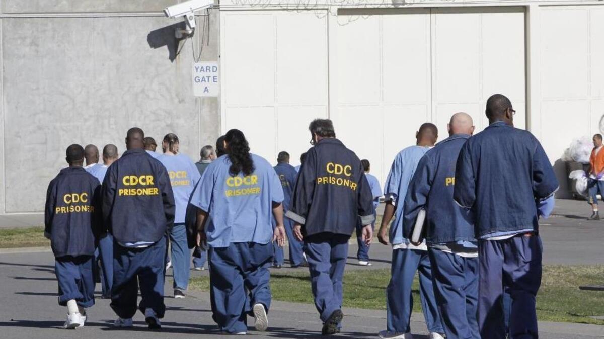 Inmates walk through the exercise yard at California State Prison, Sacramento, in Folsom in 2013. In a major setback for Gov. Jerry Brown’s sweeping prison and parole initiative, a judge on Wednesday ruled the measure was improperly filed, barring the state attorney general from issuing ballot language necessary for supporters to start collecting signatures.