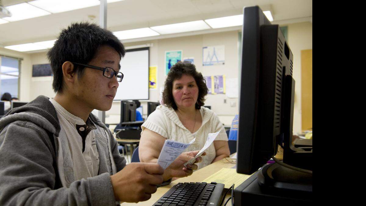 
Grant High School junior Vang Lor, left, helps Del Paso Heights resident Janice Campos file her taxes on Feb. 21, 2015. For the third year in a row, Grant staff and students were trained by IRS professionals to work with families in their community to prepare and submit their annual tax returns.
