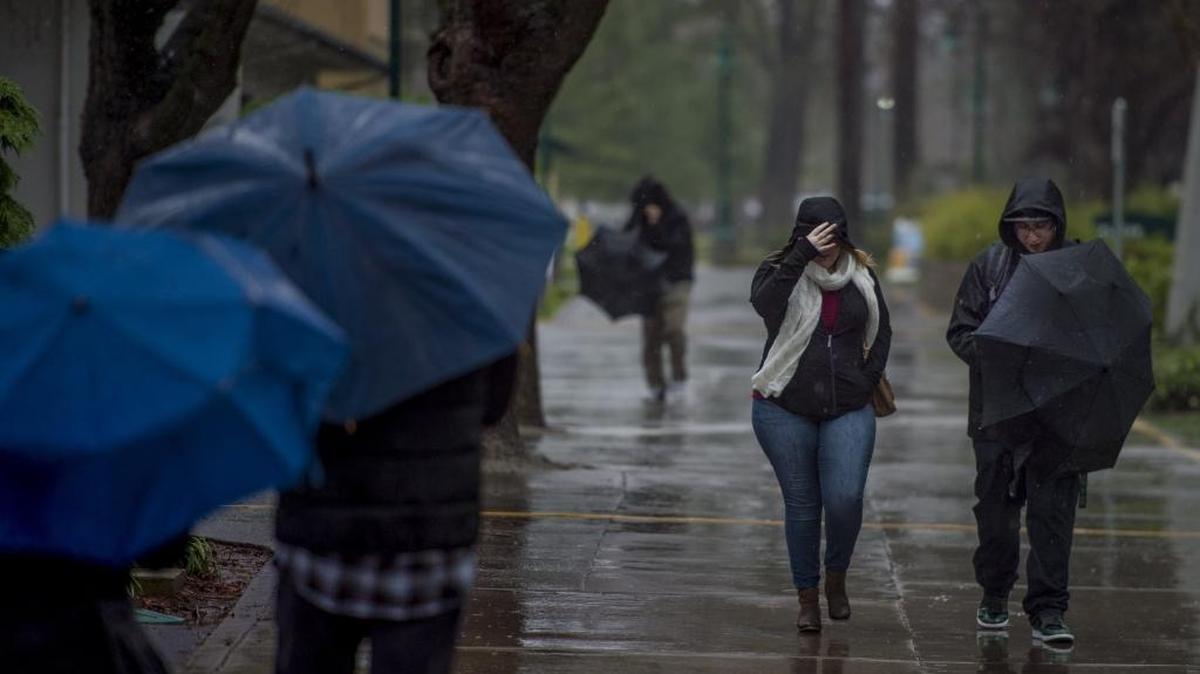 Sacramento State students brave the wind and rain near Alpine Hall on the campus of Sacramento State in January.