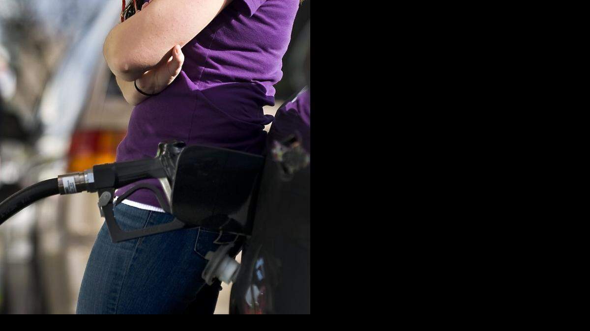 
A woman leans on her car as she fill her auto at the Chevron gas station on Watt Ave and Fair Oaks Blvd on January 13, 2010 in Sacramento, Calif.
