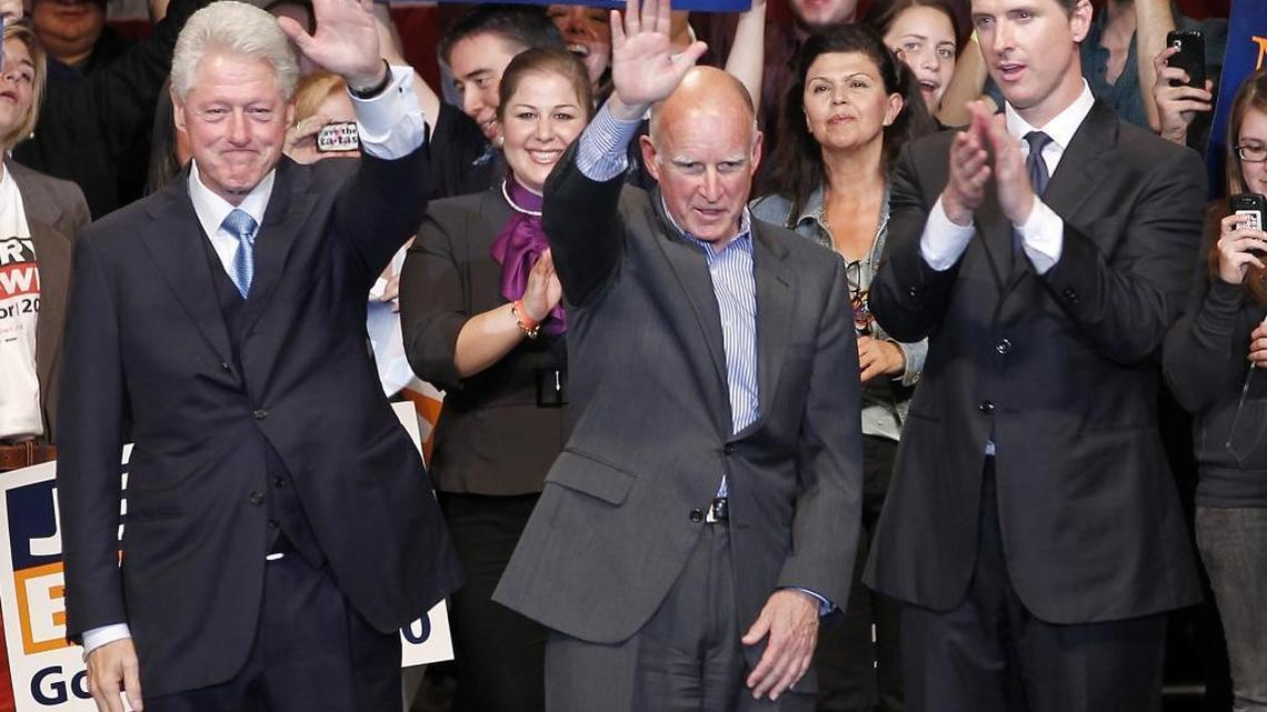 Former President Bill Clinton, left, waves to the crowd with then-California Attorney General and Democratic Gubernatorial Candidate Jerry Brown, center, and Lieutenant Governor Candidate Gavin Newsom, right, during a California Democratic Party rally on the San Jose State University campus on Sunday, Oct. 17, 2010 in San Jose, Calif.