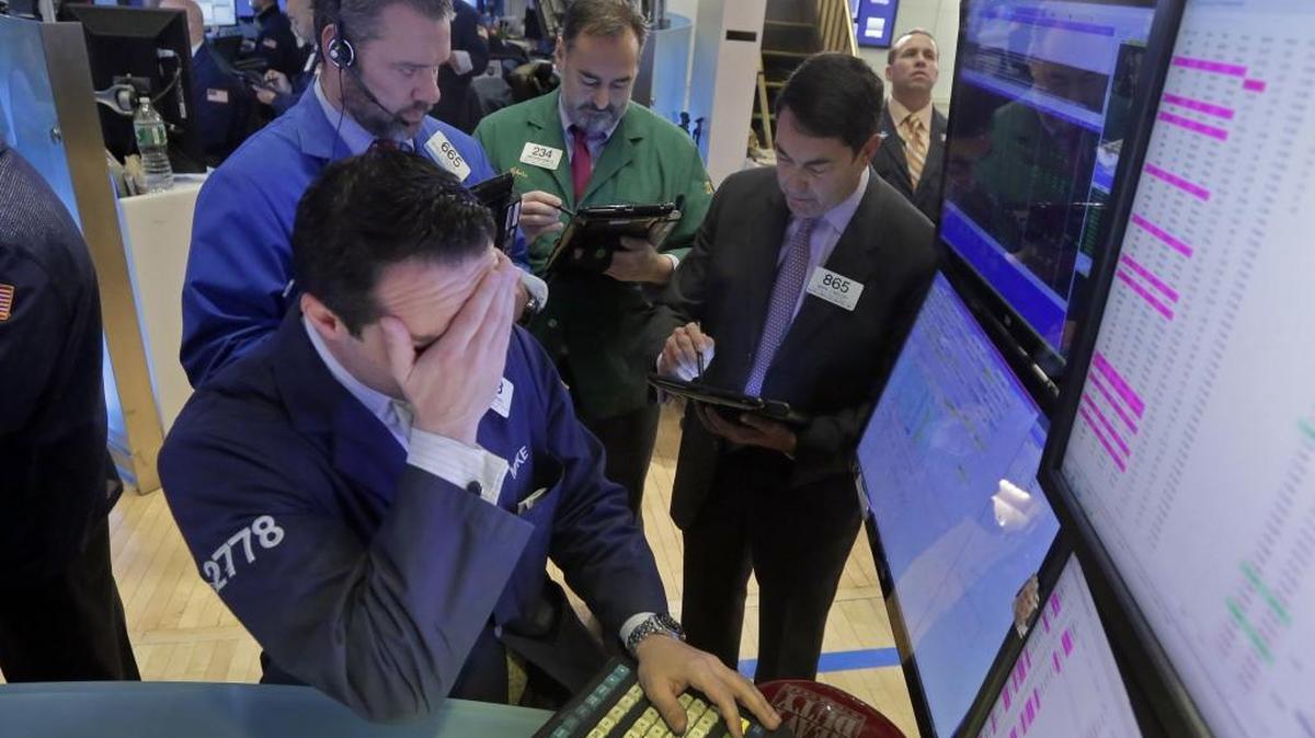 Specialist Michael Gagliano, foreground, works with traders at his post on the floor of the New York Stock Exchange, Monday, Feb. 1, 2016. The stock market’s problems likely contributed to lower-than-estimated California income tax revenue in January, the LAO reports.