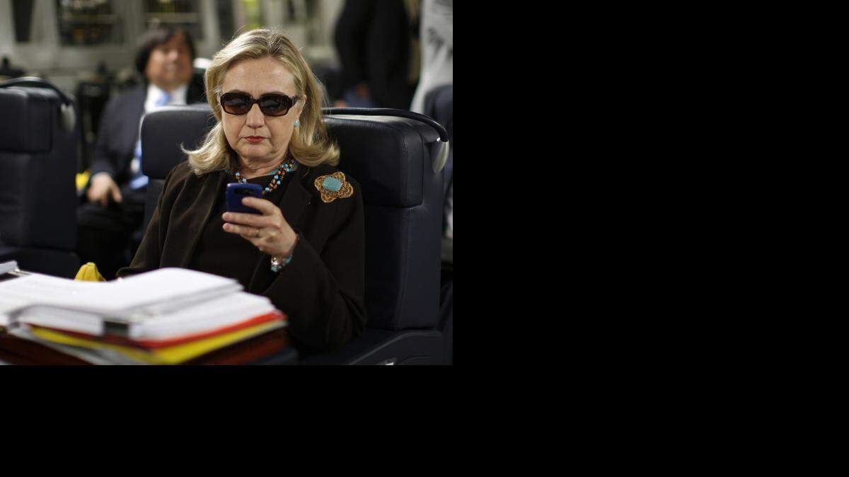 
Then-Secretary of State Hillary Rodham Clinton checks her BlackBerry inside a C-17 military plane in 2011 upon her departure from Malta, bound for Tripoli, Libya. Her use of personal email adds fire to a legal debate over what constitutes a public record.

