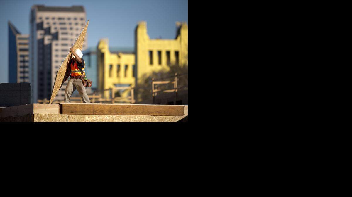 
Construction workers finish off the roof on the northwest corner of the Capitol Yards Apartments in West Sacramento on Monday afternoon, Feb. 24. 2014. 
