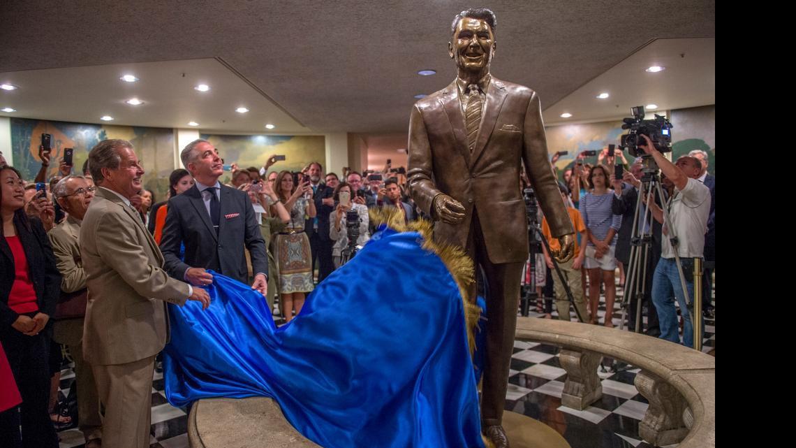 
Sculptor Douglas Van Howd, left, and Douglas Elmets, chairman of the Ronald Reagan Centennial Capitol Foundation, unveil the 8-foot-tall bronze statue of the former California governor and president during ceremonies at the Capitol in Sacramento on Monday.
