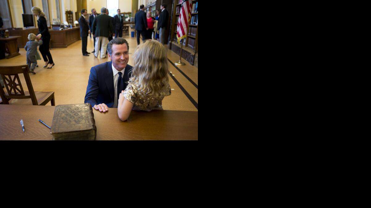 
Lt. Gov. Gavin Newsom talks to his daughter Montana, 5, about his inscription in the bible used for his swearing in ceremony on Monday January 5, 2015 in Sacramento, Calif.
