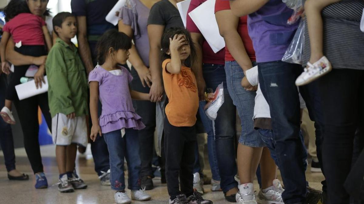 In this June 20, 2014 file photo, immigrants who entered the U.S. illegally stand in line for tickets at the bus station after they were released from a U.S. Customs and Border Protection processing facility in McAllen, Texas.