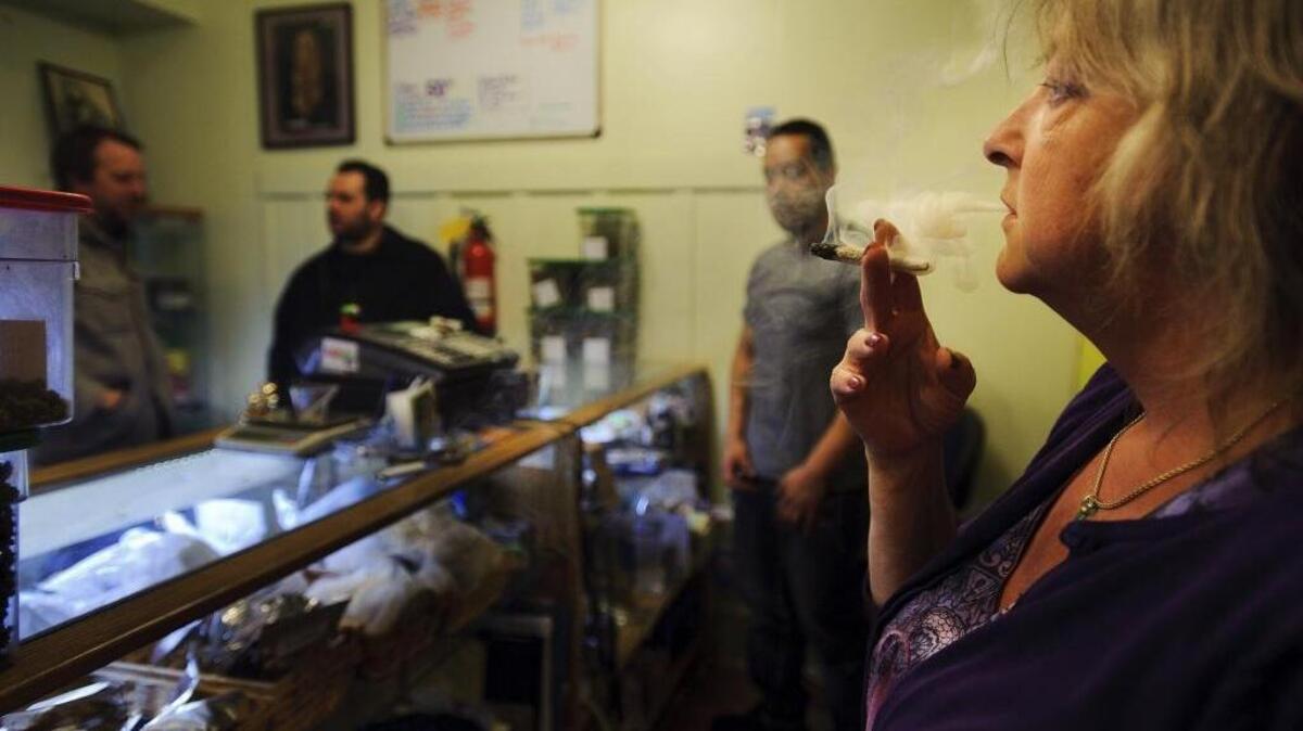 Co-founder Catherine Smith smokes marijuana at the HopeNet dispensary in San Francisco on April 10, 2012.
